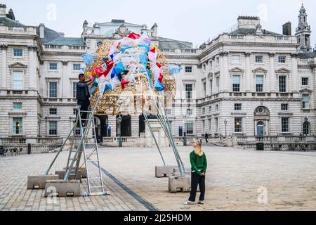 London UK 30 March 2022 der philippinische Künstler Leeroy New nimmt die letzten Anpassungen an seiner Installation vor, die noch bis zum 26. April anlässlich des Earth Day zu sehen sein wird. Es handelt sich um die erste britische Installation von New, die in Form von drei fantastischen, hochgedrehten Schiffen, die aus Plastikabfällen und recycelten Materialien gebaut wurden, in einem Höhenmeter vom Boden entfernt entsteht. Die Installation greift die Kultur und Mythologien der Heimat des Künstlers auf den Philippinen auf, einem Land an der vordersten Front der Klimanotlage. Paul Quezada-Neiman/Alamy Live News Stockfoto