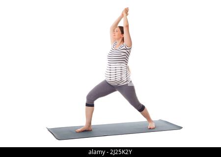 Schwangere beim Yoga Asana Virabhadrasana 1 Stockfoto