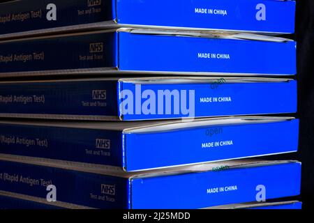 Blaue NHS Covid-19-Testkits für lateralen Fluss/Coronavrus-Testkits für schnelles laterales Flussantigen vor schwarzem Hintergrund Stockfoto