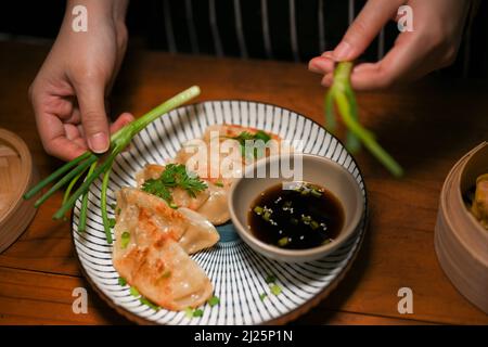 Nahaufnahme, Frau bereitet ihre speziellen chinesischen frittierten Knödel in der Küche vor. Gyoza, Dim Sum. Asiatische Küche. Stockfoto