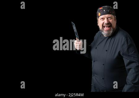 Portrait von Koch mit Messer in der Hand mit schwarzem Hintergrund und Kopierraum auf der linken Seite. Ausdruck des Konzepts. Stockfoto