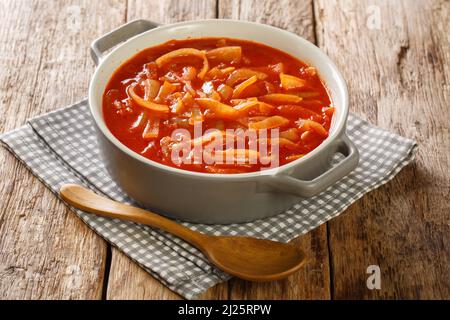 Hausgemachte Zwiebelsauce mit Tomaten, Knoblauch und Gewürzen in Nahaufnahme in einem Topf auf dem Tisch. Horizontal Stockfoto
