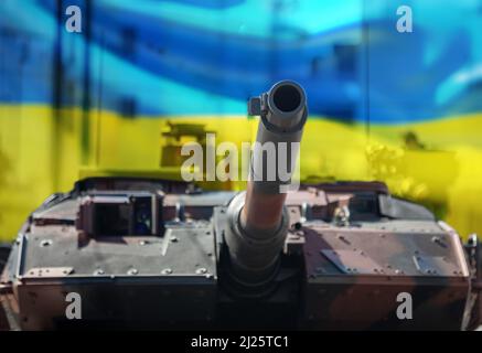 Leopard Hauptkampfpanzer, Ukraine Flagge Hintergrund. Schweres Militärfahrzeug, Stadthintergrund. Armeeausrüstung für Krieg und Verteidigung Stockfoto