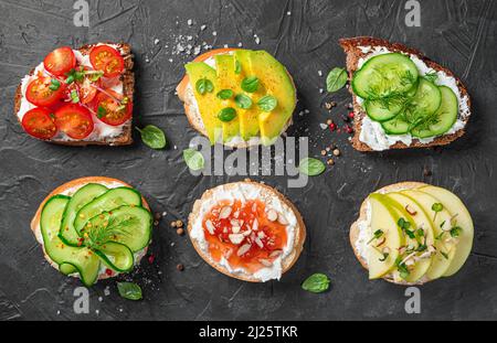 Verschiedene Sandwiches mit Gemüse und Obst auf Frischkäse. Stockfoto