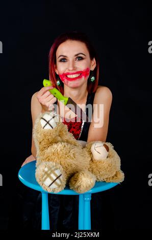 Verrückte Frau Koch mit Küchenmesser und unoooounted Teddybär, verschiedene Zutaten Stockfoto