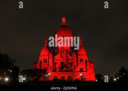 Die Basilika Sacred Heart wurde von der Wohltätigkeitsorganisation Aide a l'Eglise en Detresse, Paris, Frankreich, in Rot beleuchtet Stockfoto