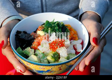 Asiatische Küche. Fischnapf mit Algen, Avocado, Gurken, Rettich, Sesam. Stockfoto