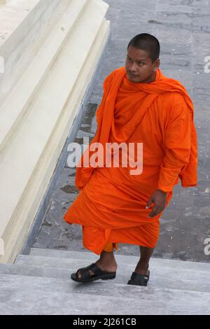 Buddhistischer Mönch, der traditionelle Safranroben trägt, nähert sich dem Wat Preah Keo Morokat, aka Silver Pagode, Phnom Penh, Kambodscha Stockfoto