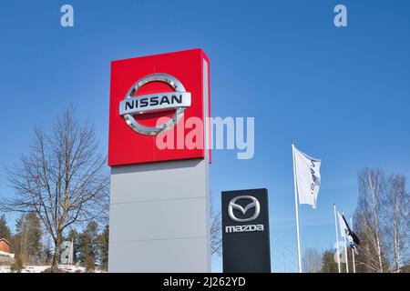 Nissan und Mazda Schilder gegen blauen Himmel im Freien Stockfoto