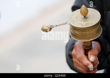 Bodhnath Stupa. Tibeter auf einer Pilgerreise mit einem Mani-Gebetsrad. Stockfoto