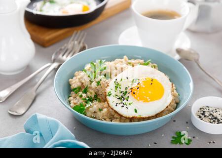 Herzhafte Haferflocken mit Spiegeleiern zur Sonnenseite zum Frühstück Stockfoto