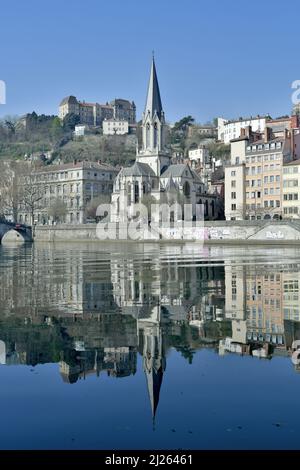 Schönes Bild der Kirche Saint George, das sich im Licht eines Frühlingsvormittags in Lyon, Frankreich, in der Saone widerspiegelt. Stockfoto