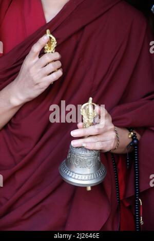 Kloster Pema Osel Ling. Buddhistischer Mönch in einem Lama-Kleid. Der Mönch hält die rituellen Attribute Buddhismus, Rosenkranz, Vajra, Glocke. Stockfoto