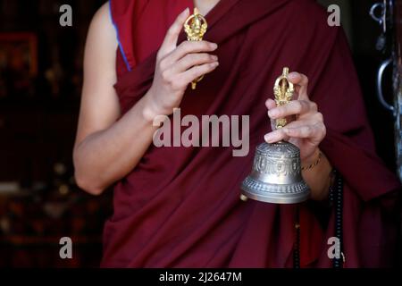 Kloster Pema Osel Ling. Buddhistischer Mönch in einem Lama-Kleid. Der Mönch hält die rituellen Attribute Buddhismus, Rosenkranz, Vajra, Glocke. Stockfoto