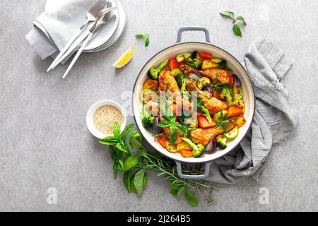 Hähnchenschenkel mit Gemüse gebacken. Draufsicht Stockfoto