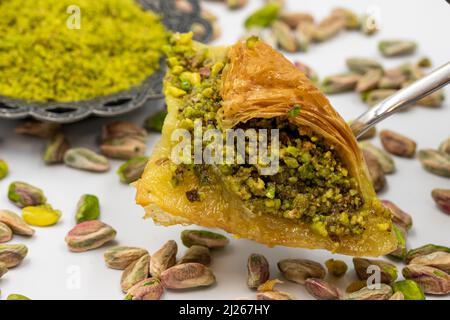 Pistazien-Baklava auf weißem Hintergrund. Traditionelle türkische Küche Delikatessen. Lokaler Name fistikli sobiyet baklava Stockfoto