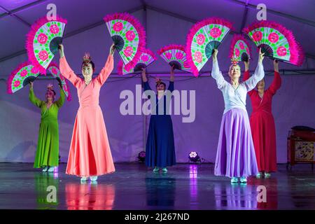 Eine Gruppe koreanischer Frauen in hanbok-Kleidern führt während der Feierlichkeiten zum Mid-Autumn-Festival einen Fächertanz auf der Bühne auf Stockfoto