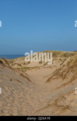 Blick zwischen Marram Gras bewachsenen Sanddünen in Richtung Meer, bei Formby in Merseyside Stockfoto
