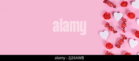Banner mit Valentinstag Süßigkeiten, herzförmigen Konfetti und roten Rosen auf der Seite von rosa Hintergrund mit Copy Space Stockfoto