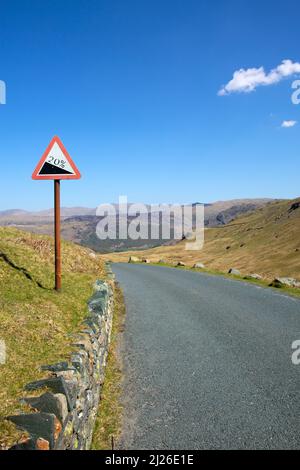 Ein Straßenschild zeigt 20 % auf dem Honister Pass, der nach Osten in Richtung Borrowdale, Lake District, Cumbria, England, blickt Stockfoto