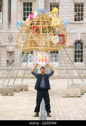 NUR FÜR REDAKTIONELLE VERWENDUNG der Künstler Leeroy New startet seine Installation The Arks of Gimokudan im Somerset House, London. Die Außenanlage, die anlässlich des Earth Day 2022 in Auftrag gegeben wurde, besteht aus drei erhöhten Schiffen, die aus Kunststoffabfällen und recycelten Materialien gebaut wurden. Bilddatum: Mittwoch, 30. März 2022. Stockfoto