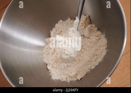 Berlin, Deutschland. 30. März 2022. ABBILDUNG - Mehl befindet sich in einer Rührschüssel. Quelle: Annette Riedl/dpa/Alamy Live News Stockfoto