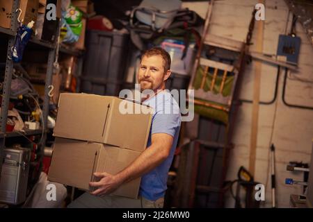 HES auf der Oberseite des beweglichen Spiels. Porträt eines jungen Mannes, der Kisten verpackt. Stockfoto