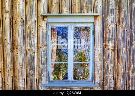 Fenster an einer alten, unbemalten Holzwand Stockfoto