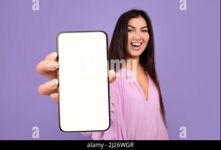Schöne Junge Frau Demonstriert Big Blank Smartphone In Ihrer Hand Stockfoto