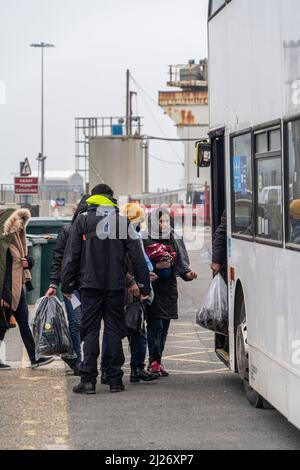 Dover, Großbritannien. 28. März 2022. Eine Flüchtlingsfamilie geht in einen Bus in Dover. Eine zweite P&O-Fähre, die Pride of Kent, wird festgenommen, nachdem sie aufgrund der Gegenreaktion auf die Entscheidung des Unternehmens, 800 Seeleute durch weniger bezahlte Besatzungsmitglieder zu ersetzen, die Sicherheitskontrollen durch die Behörden nicht bestanden hat, berichtet Sky News. (Foto von Edward Crawford/SOPA Images/Sipa USA) Quelle: SIPA USA/Alamy Live News Stockfoto