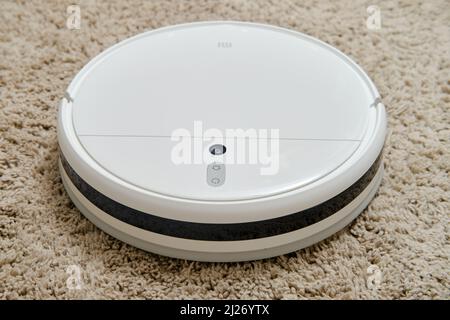 Weißer Roboter-Reiniger Xiaomi Mi Staubsauger-Mop auf flauschigen Teppich, Nahaufnahme - Moskau, Russland, 05. März 2022 Stockfoto