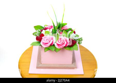 Komposition aus Blumen und Beeren in einer Pappschachtel, isolierter weißer Hintergrund. Stockfoto