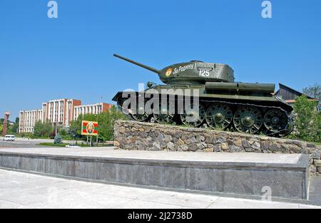 Tiraspol, Transnistrien, Moldawien: Das Panzerdenkmal mit dem Gebäude der transnistrischen Regierung dahinter. Stockfoto