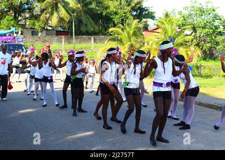 PUNTA GORDA, BELIZE - 10. SEPTEMBER 2015 St. George’s Caye Day Feiern und Karneval Linie von Mädchen in schwarz und weiß mit grünem Gras Stockfoto