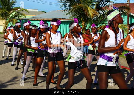 PUNTA GORDA, BELIZE - 10. SEPTEMBER 2015 St. George’s Caye Day Feiern und Karneval mit Mädchen tanzen in schwarz, weiß und lila Stockfoto