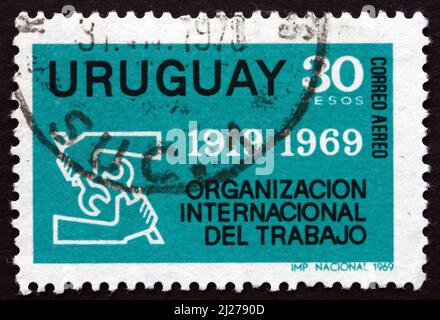 URUGUAY - UM 1969: Eine in Uruguay gedruckte Briefmarke zeigt das ILO-Emblem, um 1969 Stockfoto