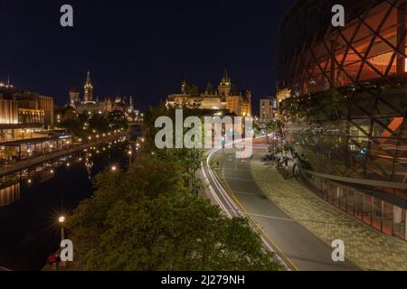 Das Ottawa Convention Center, bei Sonnenuntergang, mit dem Parlament und dem Rideau-Kanal im Hintergrund Stockfoto