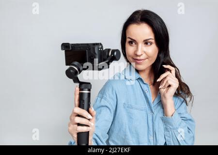 Junge attraktive Frau nimmt ein Selfie mit Kamera auf Gimbal Stockfoto