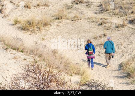 Zwei Spaziergänger, die in den Sanddünen des Naturparks De Westhoek / West Corner bei De Panne, Westflandern, Belgien, wandern Stockfoto