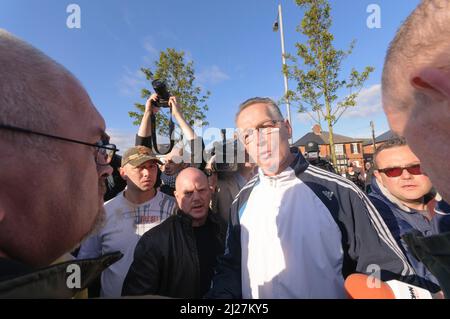 14/08/2010, Crumlin Road, Belfast, Nordirland. Gerry Kelly (Sinn Fein) versucht mit dem politischen Aktivisten Martin Og Meehan zu argumentieren, einen Protest von Ardoyne-Bewohnern gegen die Parade der Auszubildendenjungen von Derry abzusagen. Stockfoto