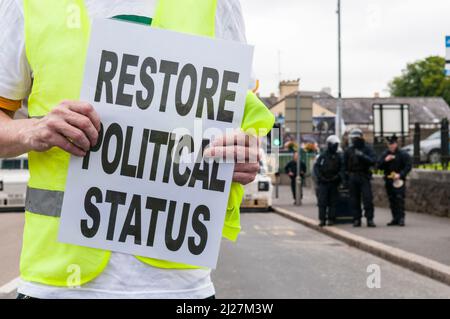 25/07/2010, Lurgan, Nordirland. Ein Mann hält ein Protestplakat mit der Aufschrift „Wiederherstellung des politischen Status“, während Familien republikanischer Gefangener im Maghaberry Gefängnis eine illegale Parade durch Lurgan abhalten. Stockfoto