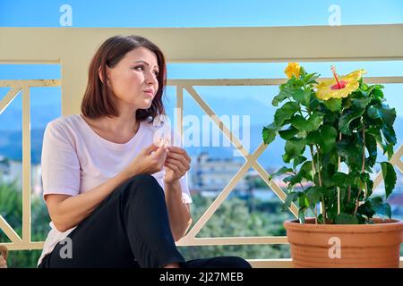 Traurige reife einsame Frau zu Hause auf der Terrasse Stockfoto