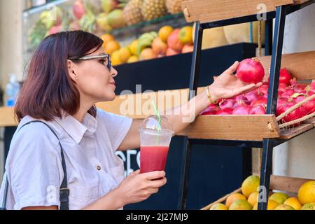 Frau in der Obstsaftbar im Freien mit frischem Saft Stockfoto