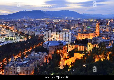 Stadt Malaga mit Alcazaba mittelalterliche Festung und Kathedrale beleuchtet in der Dämmerung, erhöhte Ansicht von Gibralfaro Hügel, Andalusien Spanien. Stockfoto