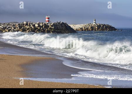 Steinpiers mit Leuchttürmen, große Wellen krachen an der Küste von Nazare in Portugal. Stockfoto