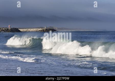 Steinpiers mit Leuchttürmen, große Wellen krachen an der Küste von Nazare in Portugal. Stockfoto