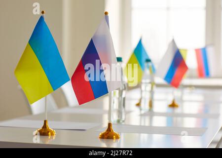 Tisch mit Flaggen Russlands und der Ukraine im Konferenzraum nach dem Verhandlungstreffen Stockfoto