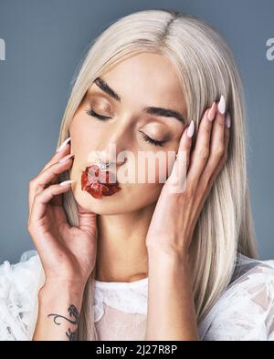 In meinem Rahmen liegt eine Kraft. Porträt einer attraktiven jungen Frau, die ihre Tattoos mit grauem Hintergrund zeigt. Stockfoto