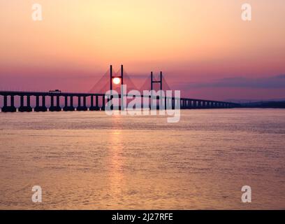 Sonnenuntergang hinter den Stütztürmen der Prince of Wales Bridge, die die Severn-Mündung zwischen England und Wales UK überquert Stockfoto
