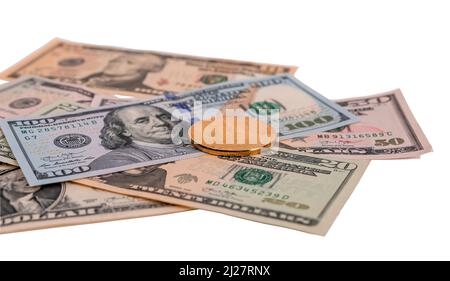 Dollar-Banknoten und Goldmünzen isoliert auf weißem Hintergrund. Stockfoto